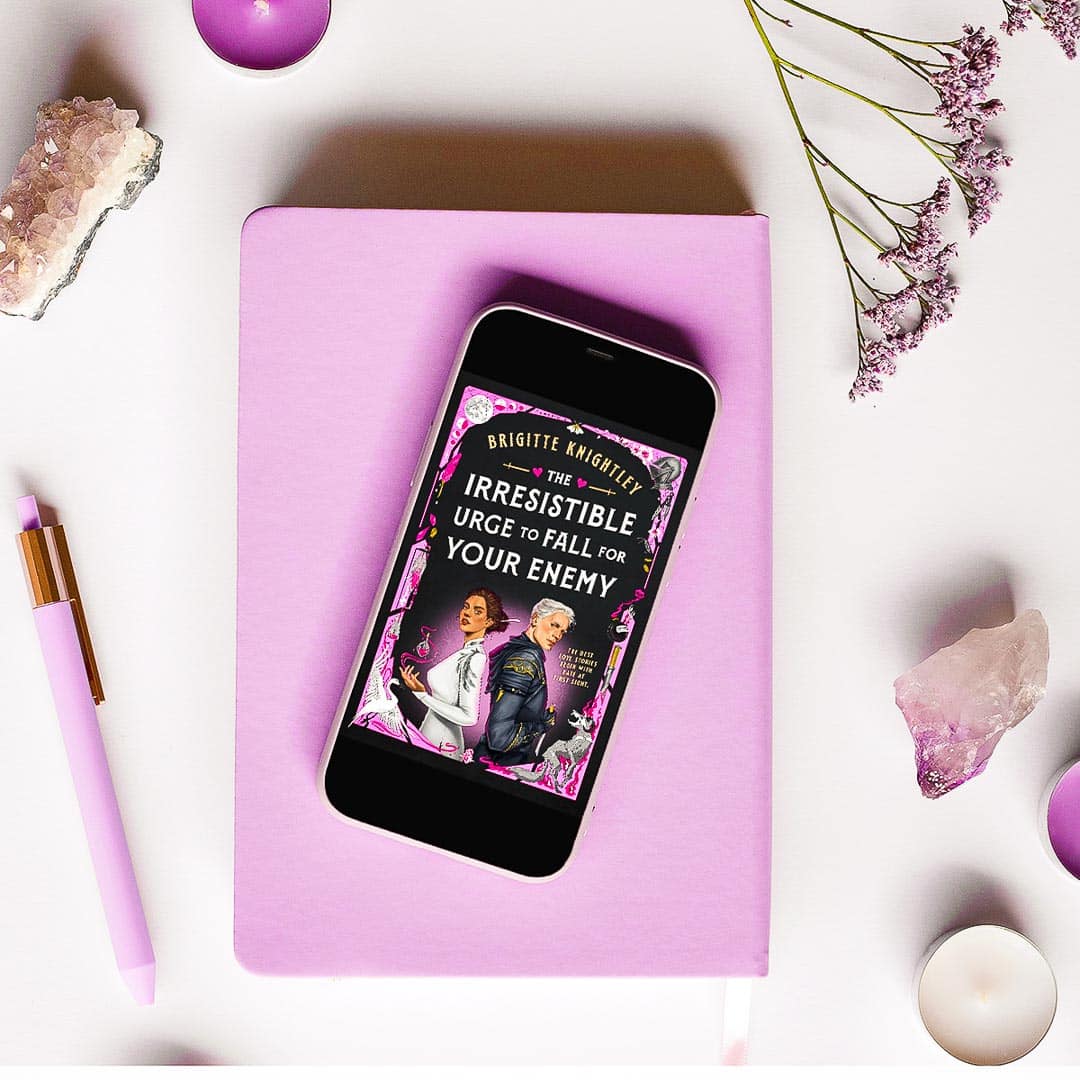 The Irresistible Urge to Fall For Your Enemy by Brigitte Knightley on a pink notebook on a desk